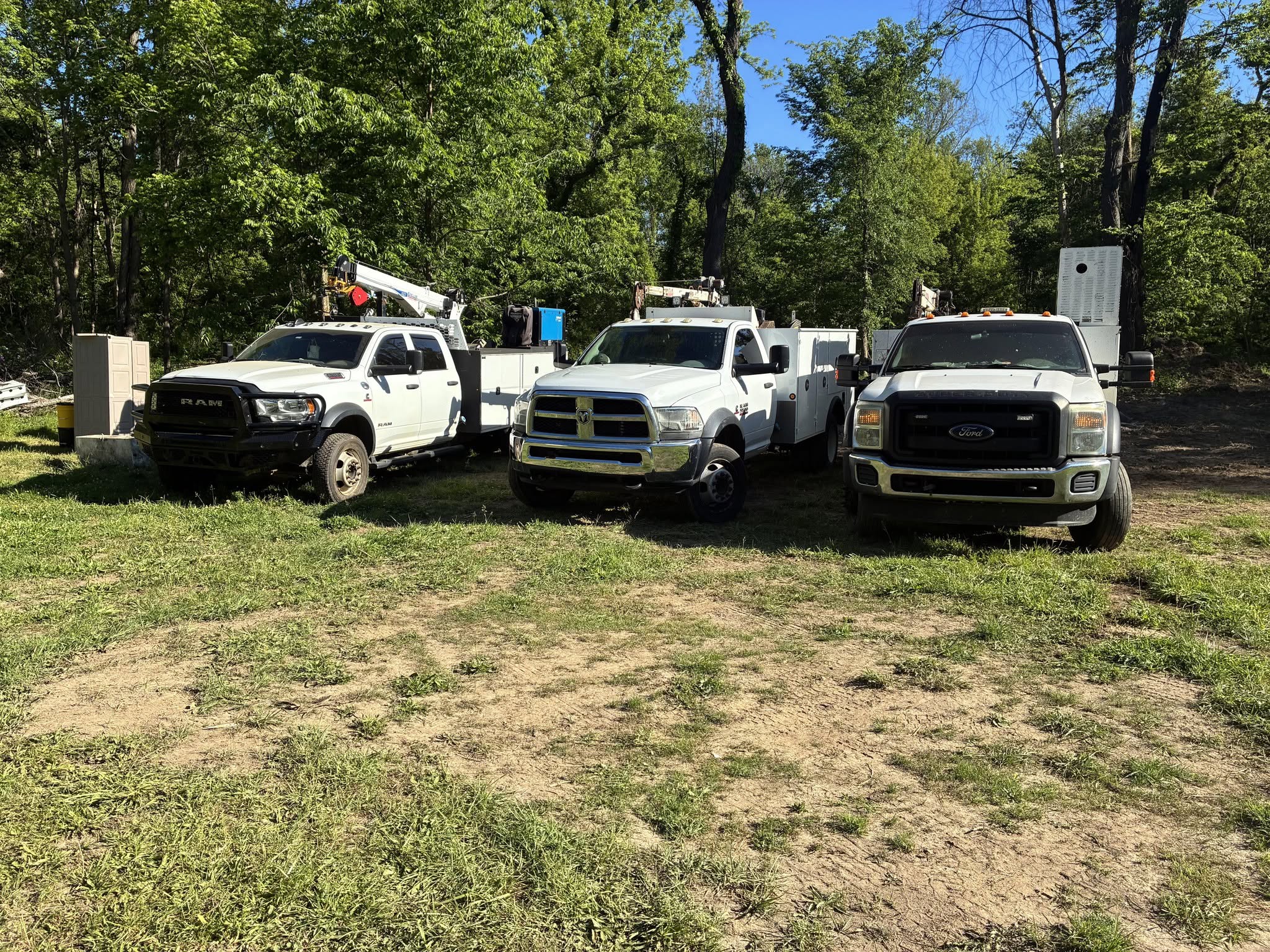 Three field service trucks equipped with utility bodies and cranes